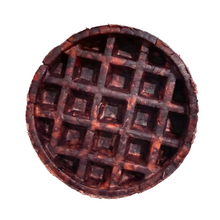 Load image into Gallery viewer, A single round waffle with a deep grid pattern, showing a dark brown and reddish-brown marbled texture, isolated on a solid white background.