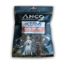 Load image into Gallery viewer, Anco Oceans Salmon Skin Cubes dog treats in a dark blue resealable pouch with a white and red label, featuring photos of two dogs on the front.