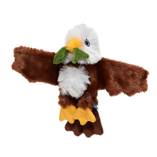 Load image into Gallery viewer, A plush bald eagle toy with spread wings, featuring brown fur, a white head and chest, yellow beak and feet, and green leaves in its beak, shown on a plain white background.