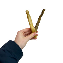 Load image into Gallery viewer, Hand holding two Nova Buffalo Collagen Stick against a white background