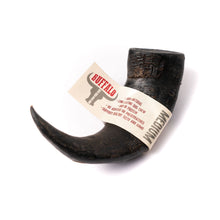 Load image into Gallery viewer, A medium-sized black buffalo horn dog chew toy with a label attached to it.