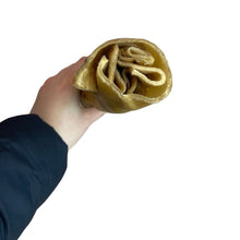 Load image into Gallery viewer, Hand holding a rolled-up Nova Jumbo Buffalo Roll against a white background