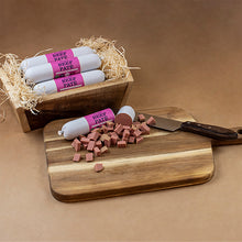 Load image into Gallery viewer, Beef pate sausages with packaging on a wooden cutting board and tray.