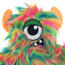Load image into Gallery viewer, A close-up of a colorful, furry monster plush toy with bright neon green, pink, blue, and yellow hair, orange ears, and a large embroidered eye patch on a white background.