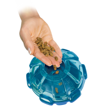 Load image into Gallery viewer, Blue pet puzzle toy with a hand adding kibble into it on a white background