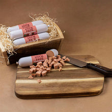 Load image into Gallery viewer, Duck pate sausages on a wooden board with a knife, against a brown background