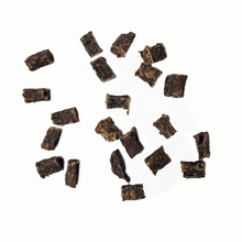 Load image into Gallery viewer, Dried black tea leaves scattered on a white background