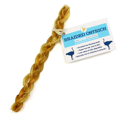 A braided ostrich-flavored dog treat hanging from a card with product information.