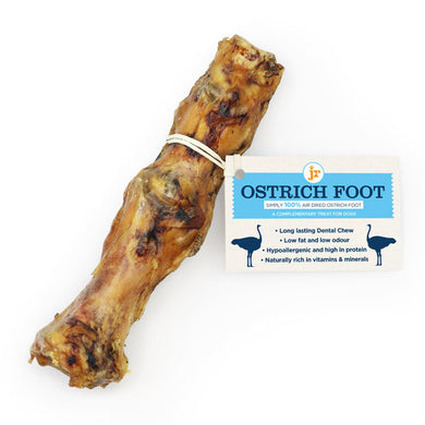A single JR Ostrich Skin dog treat, which is a dried and partially consumed ostrich foot, displayed on a white background with a label that provides product information.