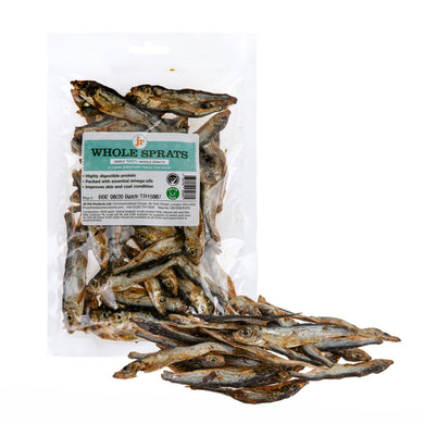 A clear plastic package with a label showing dried whole Baltic sprats, with some sprats scattered in front of the package.