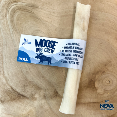 A rolled-shaped dog chew made from moose hide, placed on a wooden surface with a label that provides product information.