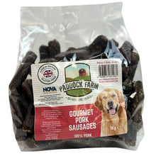 Load image into Gallery viewer, A 1kg bag of Nova Pork Farm Gourmet Pork Sausages for dogs, containing dark brown cured sausages visible through a clear plastic bag with a white and red label featuring a golden retriever.
