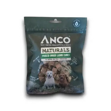 Load image into Gallery viewer, A package of Anco Naturals Freeze-Dried Lamb Cubes dog treats, shown against a plain white background. The packaging is a dark green resealable pouch with a clear window displaying the freeze-dried brownish-tan cubes inside, and features images of a white Labrador and a brown dog.
