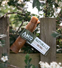 Load image into Gallery viewer, Anco Naturals Yax Roll tied to a wooden post with greenery in the background
