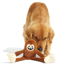 Load image into Gallery viewer, A golden retriever dog is sniffing a brown plush monkey toy with white paws and a smiling face, photographed on a clean white background.

