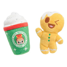 Load image into Gallery viewer, Two plush dog toys on a white background: a green holiday coffee cup toy with white foam and a yellow gingerbread person toy.
