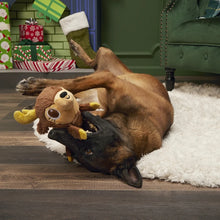 Load image into Gallery viewer, Dog playing with a stuffed monkey toy on a wooden floor with Christmas decorations in the background.
