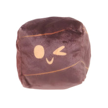 Load image into Gallery viewer, A square-shaped plush toy with a dark brown velvet-like texture, featuring a simple beige face with one winking eye and a curved smile, set against a plain white background.
