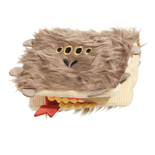 Load image into Gallery viewer, A plush novelty item shaped like a book with a furry brown monster face on top, featuring four black eyes with gold outlines, a small black nose, yellow teeth, a red ribbon bookmark, and cream-colored page edges, shown on a plain white background.
