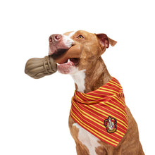 Load image into Gallery viewer, Dog wearing a red and yellow bandana with a crest, holding a brown dog toy.
