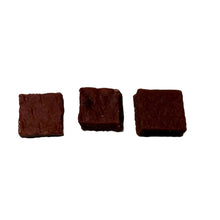 Load image into Gallery viewer, Three square pieces of Beef &amp; Beef-Heart Bites 100g on a light gray surface
