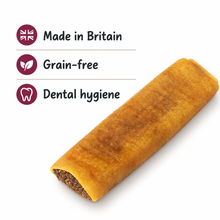 Load image into Gallery viewer, A rolled golden-brown dog chew or treat shown on a white background with text callouts reading 'Made in Britain', 'Grain-free', and 'Dental hygiene'.
