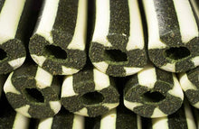 Load image into Gallery viewer, Close-up of a stack of black and white striped foam tubes with hollow centers, showing textured ends and alternating dark and light bands.
