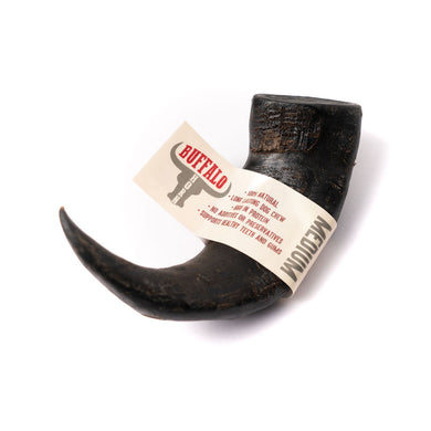 A medium-sized black buffalo horn dog chew toy with a label attached to it.