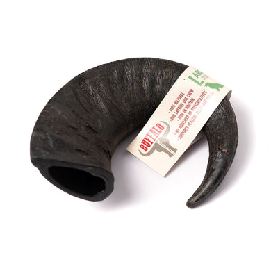 A natural black buffalo horn dog chew toy with a label attached.