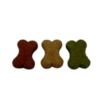 Load image into Gallery viewer, Three small bone-shaped dog treats in reddish brown, tan, and olive green arranged in a row on a white surface.
