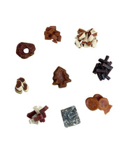 Load image into Gallery viewer, A variety of small dog treats arranged on a plain white background, including a ring-shaped treat, a Christmas tree-shaped treat, a striped treat, a dark dried treat pile, a pair of small shoes-shaped treats, a fish-shaped treat, and a square marbled treat.
