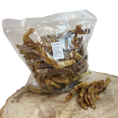 Packaged duck feet treats for dogs displayed on a wooden surface.