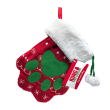 Load image into Gallery viewer, A red Christmas stocking dog toy with a green paw print design, white faux fur trim, a red hanging loop, and a red and white Kong brand hangtag.
