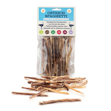 Load image into Gallery viewer, A package of FJ Ostrich Spaghetti dog treats with several dried spaghetti-like sticks scattered in front on a white background.
