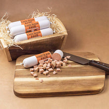 Load image into Gallery viewer, Chicken pate packages on a wooden board with a knife and cut pieces, against a brown background.
