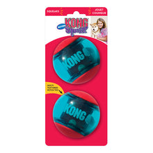 Load image into Gallery viewer, Two red and blue KONG Squeezz Action dog toys are packaged on a hanging retail card, with one toy visible in the foreground and the other in the background. The toys have a textured surface and a squeaker inside for interactive play.
