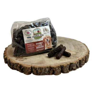 Packaged Nova Small Liver Sausages placed on a wooden surface, with several sausages visible outside the packaging.