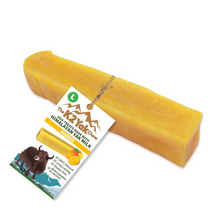 Load image into Gallery viewer, A bar of yellow goat milk soap shaped like a cheese wedge, with a paper tag attached. The tag reads 'The Krazy Chew' and 'Hummus Milk' with 'MEXICO' at the bottom, and features a picture of a yucca cow.
