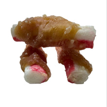 Load image into Gallery viewer, Three small dog treats shaped like legs, wrapped in a glossy golden-brown sauce and finished with white and pinkish-red ends, standing on a light speckled surface.

