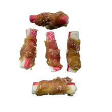 Load image into Gallery viewer, Five rolled dog treats wrapped in bacon, arranged on a light speckled countertop.
