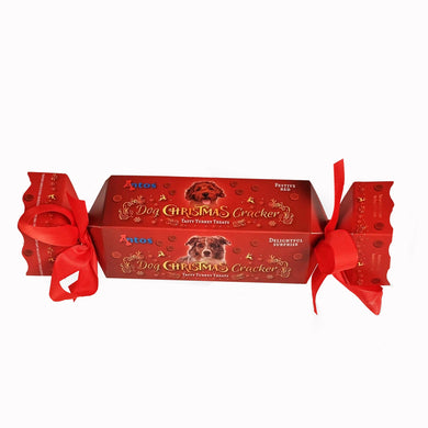 A red and gold dog Christmas cracker from Nova, tied with a red ribbon and featuring an image of a dog and the text 'I WISH YOU A MERRY CHRISTMAS'.